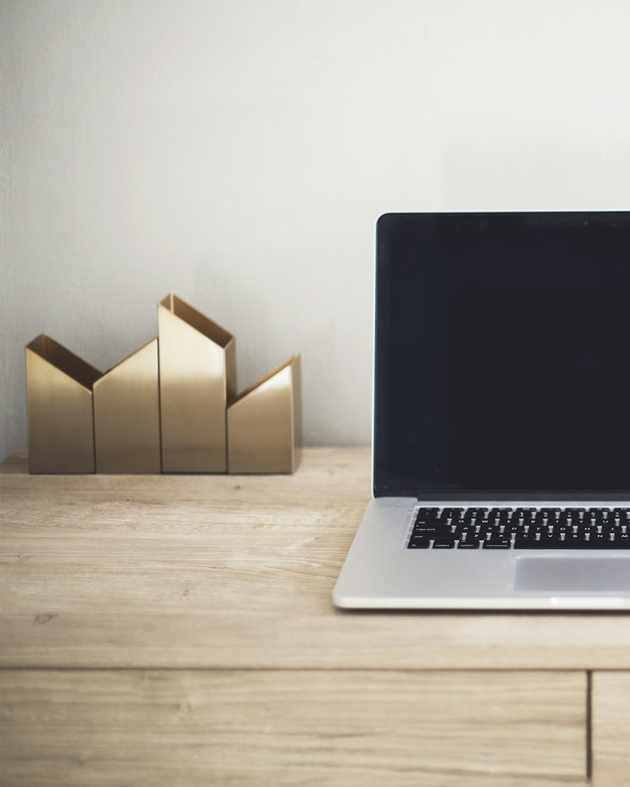 A 14-inch laptop open on a light oak desk